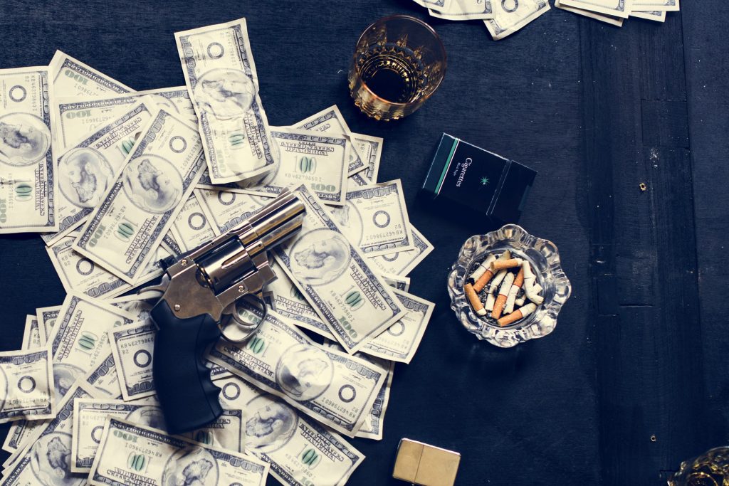 Pistola sobre el dinero en la mesa